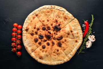 Pizza Volcano. Gorgonzola cheese, cherry tomatoes, fresh vegetables, and spices. On a wooden background. Free space for your text. Top view.