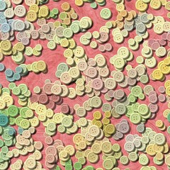 a lot of pastel multi colored vintage clothing plastic buttons randomly scattered on old pink background - top view