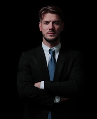 Handsome business man isolated on black with arms crossed