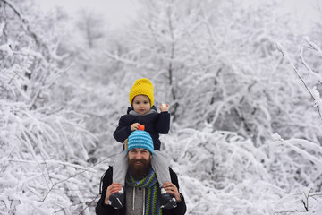 Snowball game. Playing snowballs, happy child plays with snow and bearded cheerful father. Friendship in childhood, father's support. Boy with man walking through a snowy winter park