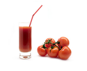 A glass with tomato juice with drinking straw and three ripe tomatoes studio shot isolated on white background