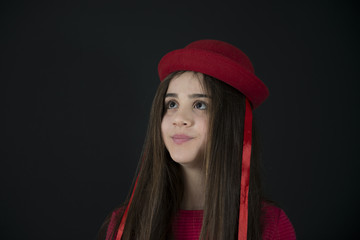 Portrait of a 12y old girl with red dress and hat