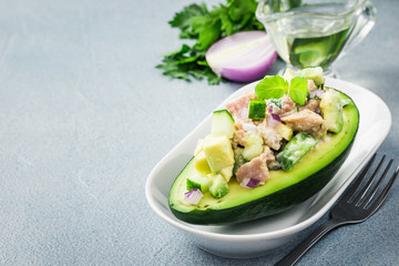 Healthy curried tuna avocado salad on concrete background. Selective focus, copy space. 