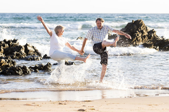 lovely senior mature couple on their 60s or 70s retired walking happy and relaxed on beach sea shore in romantic aging together