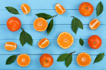 orange or tangerine with leaves on blue wooden background. Flat lay, top view. Fruit composition