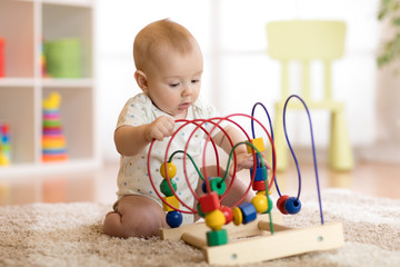 baby playing with educational toy in nursery