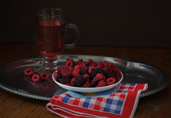 Fresh raspberries and blackberries and a glass of raspberry juice