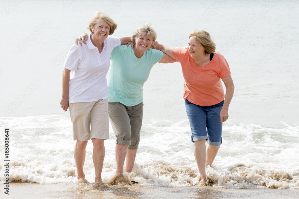 Wall mural group of three senior mature retired women on their 60s having fun enjoying together happy walking o