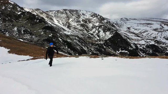 Young man hiking on mountain top in winter