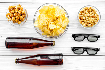 Cinema food. Crisp, popcorn, rusks near glasses on white wooden background top view
