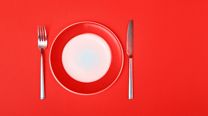 Empty Round Plate with Fork and Knife Top View Isolated on  yellow Background. Table Setting