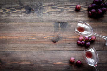 Fototapeta na wymiar Glass with wine sediment and grape on dark wooden background top view copyspace