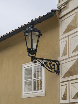 close up old street lamp lantern on renassaince palace yellow white facade in prague castle