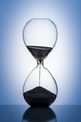 Hourglass on a blue background. Close-up. - 185015018