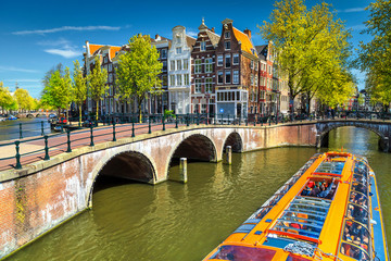 Typische Amsterdamse grachten met bruggen en kleurrijke boot, Nederland, Europa