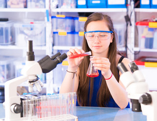 A teenage girl in a school laboratory in chemistry and biology classes