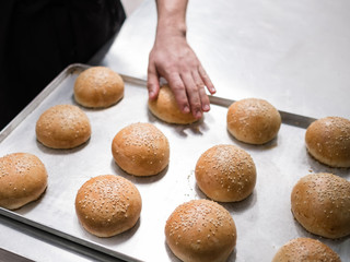 Freshly baked hamburger rolls. Preparing delicious buns in professional restaurant kitchen