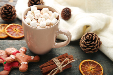 Cappuccino with marshmallow in mug and gingerbread cookies on wooden table