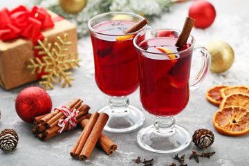 Mulled wine in glasses with spices on wooden table