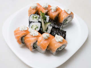 Philadelphia sushi rolls on a plate on white background. Asian cuisine and traditional Japanese food concept