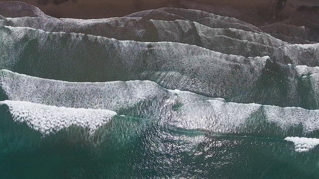 Top aerial view frop drone of Tropical exotic beach with volcanic sand in Bali, Indonesia