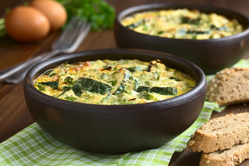 Zucchini und Petersilien Frittata in rustikale Schüsseln, fotografiert mit natürlichem Licht (Selektiver Fokus, Fokus ein Drittel in die erste Frittata)