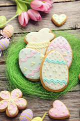 Easter cookies in green nest on wooden table