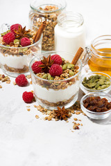 spicy dessert with sweet granola and yogurt in the glass, vertical top view