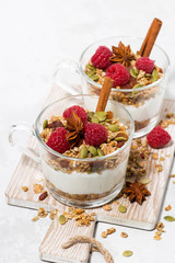 spicy dessert with sweet granola and yogurt on wooden board, vertical top view