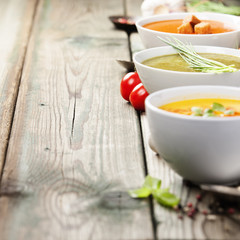 Variety of cream soups over old wood background