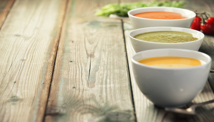Variety of cream soups over old wood background