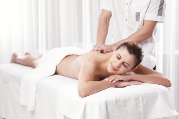 Obraz na płótnie Canvas Professional masseur doing massage of female back in the beauty salon