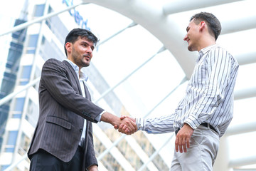 Two business man meeting partnership and shaking hands for deal success at site outdoors.