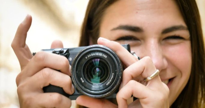 Beautiful young tourist girl, woman in Milan, holding a photo camera, taking pictures, happy smiling, background Milan gallery. Concept tourism, love travel, communication, freedom, love life shopping