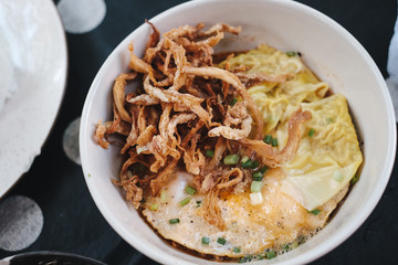 top view fusion noodle with wonton, egg and fried mushroom