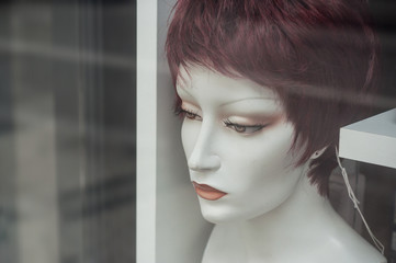 détail mannequin avec perruque en vitrine