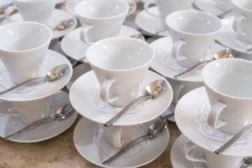 cups on saucers with teaspoons