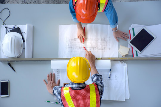 Top View Of Group Of Engineering Team Is Meeting, Planning Construction Work,looking Paper Plans At Construction Site,overhead View,Concept For Team Work