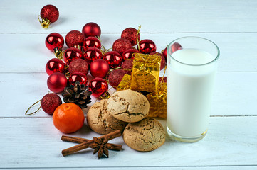 Perfect treat for Santa Claus. A glass of milk, oatmeal dietary cookies, fragrant spices and New Year's, Christmas decorations. Treats for Christmas Eve.