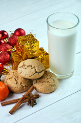 Perfect treat for Santa Claus. A glass of milk, oatmeal dietary cookies, fragrant spices and New Year's, Christmas decorations. Treats for Christmas Eve.