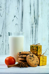 Perfect treat for Santa Claus. A glass of milk, oatmeal dietary cookies, fragrant spices and New Year's, Christmas decorations. Treats for Christmas Eve.
