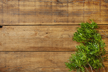 fresh green leaves on wooden surface