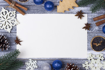 Christmas decoration card greeting, white snowflakes orange candy cane gray wooden background, blue christmas ball.
