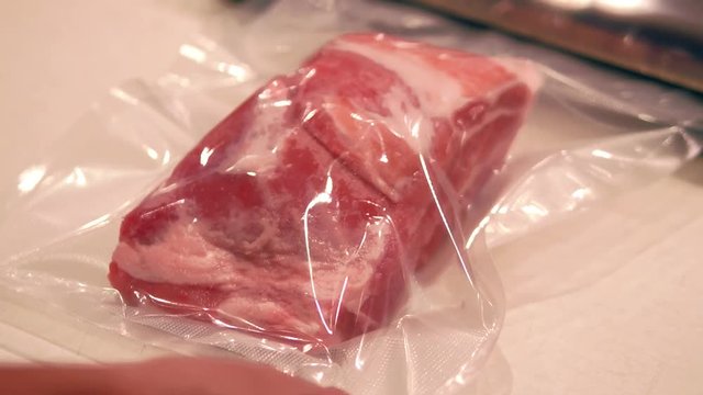 Raw meat being vacuum packed for sous vide cooking