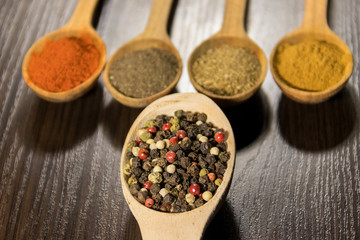 Assorted spices in wooden spoons on a table