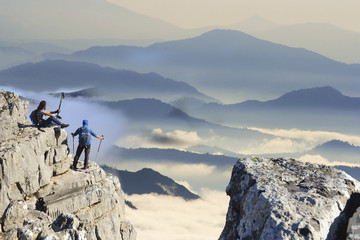 mountaineers exploring and walking in misty mountains