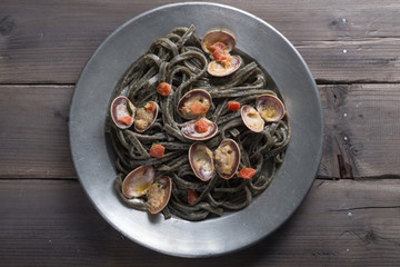 Tagliolini with cuttlefish ink, clams and tomato