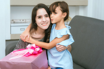 Young Woman Giving Gift Box to Little Girl in Celebrate Party at Home