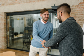 Company recruiter handshaking with the first round of candidates at a job interview