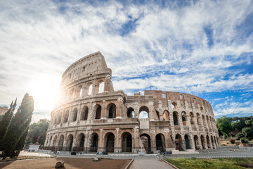 Fototapeta na wymiar Colosseum at sunrise, Rome, Italy, Europe. Rome ancient arena of gladiator fights. Rome Colosseum is the best known landmark of Rome and Italy